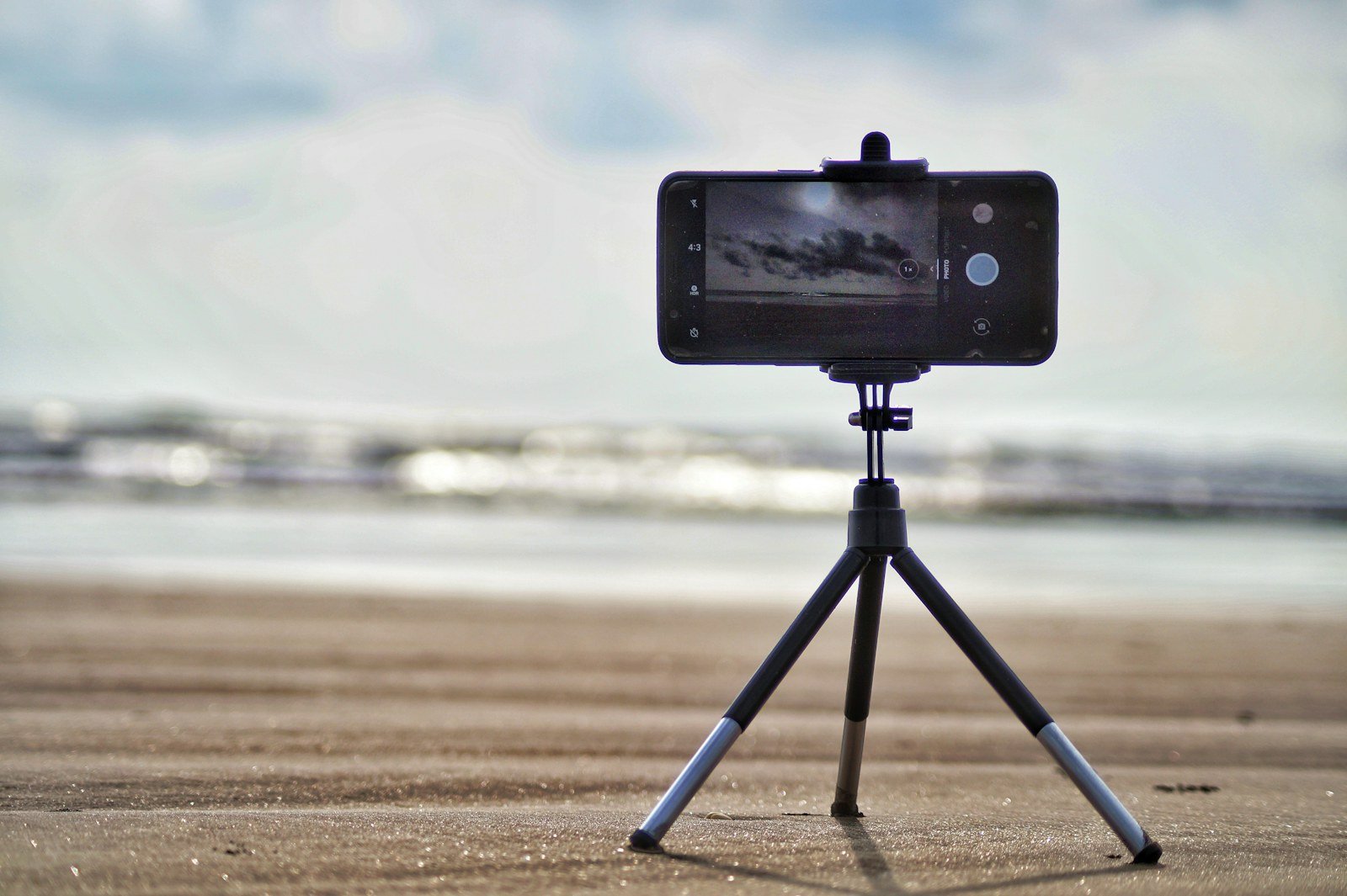 Pessoa preparando uma gravação de vídeo com smartphone e equipamentos